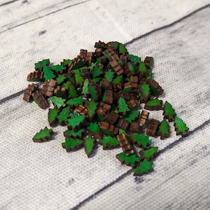 May include: A pile of small wooden Christmas tree ornaments in green and brown on a white surface.