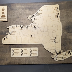 May include: Wooden map of New York State with laser-cut lighthouse markers. The map includes a separate plaque with the text "New York Lighthouses" and a list of lighthouse names. The map is mounted on a dark stained wooden board.