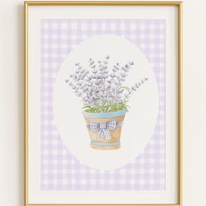 Puede incluir: Impresión en acuarela de lavanda en una maceta de terracota con una cinta azul, sobre un fondo de cuadros vichy morado y blanco. La obra de arte está enmarcada en un marco dorado, adecuada para la decoración del hogar.