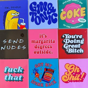 Può includere: Una collezione di nove piastrelle quadrate in ceramica con varie frasi e grafiche. Le piastrelle presentano testi come "Gin & Tonic", "Send Nudes" e "Fuck That". La tavolozza dei colori comprende rosa, blu, rosso e nero, con uno stile di carattere retrò e audace.