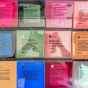 Può includere: Una collezione di piastrelle quadrate e lucide, ognuna con testi di canzoni e informazioni sull'artista, con un logo Spotify. Le piastrelle sono in vari colori, tra cui rosa, blu, verde e arancione. Il testo è in più lingue.