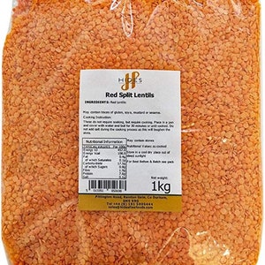 May include: A transparent bag filled with red split lentils. A label shows "Red Split Lentils" and nutritional details. The bag contains 1 kg of lentils, a staple in many recipes. The packaging is sealed.
