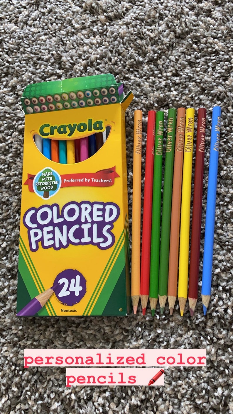 May include: A box of Crayola coloured pencils with the text "COLORED PENCILS" and "24" on the front. Several personalised pencils with the name "Oliver Wren" are next to the box. The text "personalized color pencils" is at the bottom.