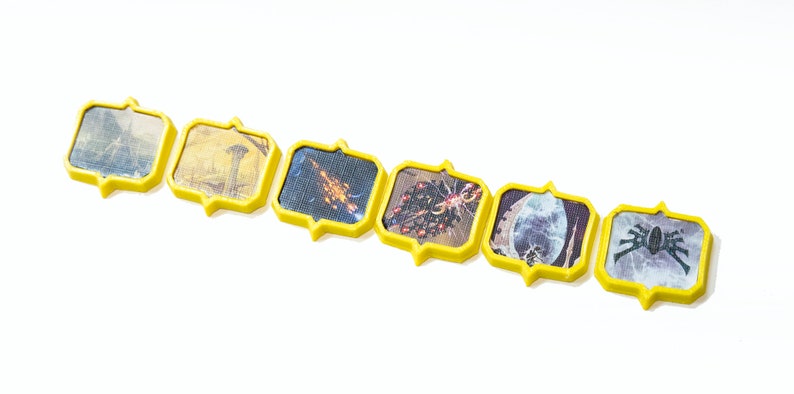 May include: A set of seven yellow picture frames with different images inside. The images include a landscape, a building, a spaceship, a cluster of stars, a skull, a spider, and a close-up of a spider.