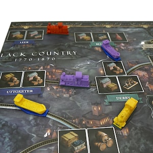 May include: A game board with a purple, yellow, and red train engine pieces. The board is titled "Black Country 1770-1870".