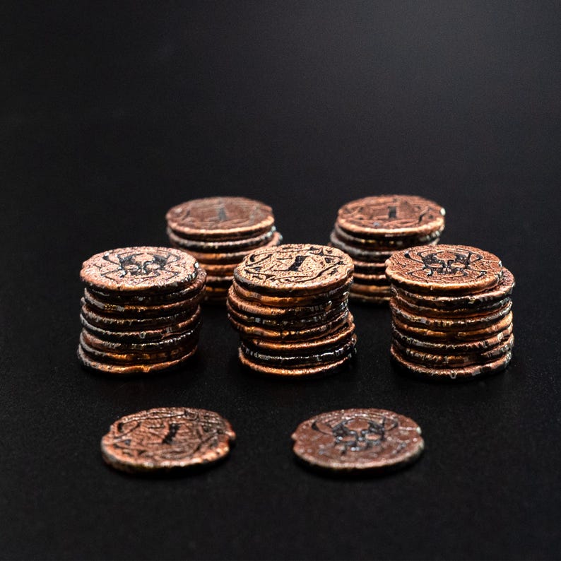 Peut inclure: Plusieurs piles de pi&egrave;ces de monnaie de couleur cuivre avec des gravures d&eacute;taill&eacute;es. Les pi&egrave;ces sont dispos&eacute;es en petits tas et dispers&eacute;es sur une surface sombre. Les pi&egrave;ces ont un aspect vieilli et antique, possiblement pour un jeu ou une collection.