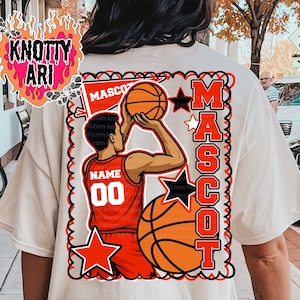 May include: Cream-colored t-shirt featuring a basketball mascot design. The design includes a basketball player in a red jersey with the number 00, basketballs, and the word "MASCOT" in bold orange letters. The shirt has a crew neck.