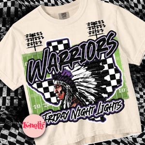 May include: A beige t-shirt featuring a graphic print of a Native American warrior wearing a headdress. The graphic is set against a checkered background with the words "WARRIORS" and "FRIDAY NIGHT LIGHTS" in purple text.