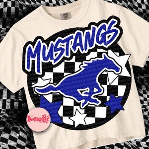 May include: A cream-colored t-shirt with a blue and black checkered circle design. The circle features a blue silhouette of a horse with the word "MUSTANGS" in blue letters above it.