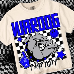 May include: A white t-shirt with a blue and gray graphic design. The graphic features a bulldog with the text "WARDOG NATION" and a blue smiley face.