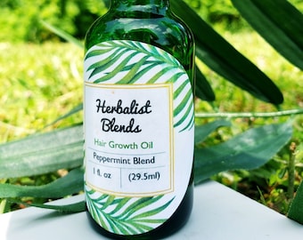 May include: A green glass bottle with a black dropper top. The bottle has a white label with the text "Herbalist Blends" and "Hair Growth Oil Peppermint Blend 1 fl. oz (29.5ml)".