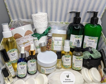 May include: A gift box filled with a variety of bath and body products, including body polish, body butter, essential oils, and soaps. The box also includes a white towel, a mug, and a small jar of dried flowers. The products are labeled "Herbal Blends" and feature a green and white tropical leaf design. The box also includes a small tag that says "Thank you for your purchase!"