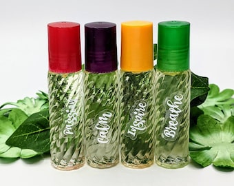 May include: Four clear glass roller bottles with colorful caps and white labels. The labels read "Passion", "Calm", "Inspire", and "Breathe".
