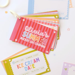 May include: A set of colorful rectangular paper coupons held together by a white plastic ring. The top card features red and pink stripes with the text Olivia's SUMMER BUCKET LIST COUPONS. Other cards include text like ICE CREAM DATE.