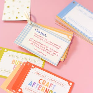 May include: A set of colorful rectangular paper tickets held together by a white plastic ring. The tickets feature various designs, including blue gingham patterns and red borders with stars. Text includes "Cooper," "Admit One," and "Craft Afternoon."