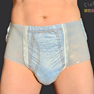 Könnte beinhalten: Eine blaue Erwachsenenwindel mit einem weißen Bund und Seitenpaneelen. Die Windel besteht aus einem weichen, saugfähigen Material.