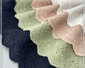 May include: Four spools of white, pink, green and black cotton lace trim with a scalloped edge and embroidered floral designs.