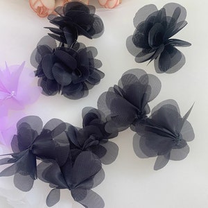 May include: Black mesh fabric flowers, with multiple layers of petals, for sewing or crafting projects.