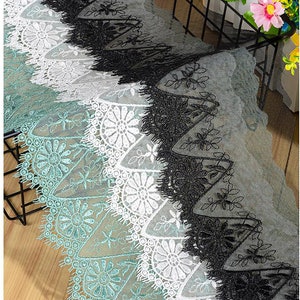 Pode incluir: Um close-up de quatro rendas diferentes. As rendas são em tons de verde, branco e preto. A renda é delicada e intrincada, com um design floral.