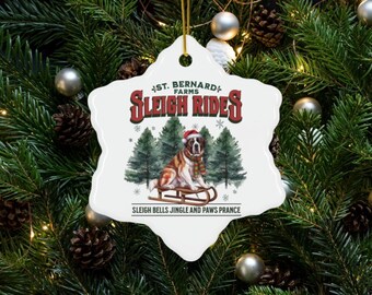 May include: White ceramic snowflake ornament with a St. Bernard dog pulling a sleigh. The ornament has the text "St. Bernard Farms Sleigh Rides" and "Sleigh Bells Jingle and Paws Prance".