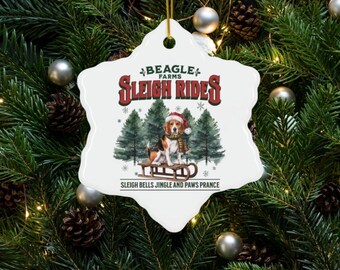 May include: White ceramic snowflake ornament with a beagle dog on a sled in a winter forest scene. The ornament reads "Beagle Farms Sleigh Rides" and "Sleigh Bells Jingle and Paws Prance".