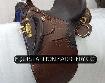 May include: A brown leather saddle with gold hardware and stitching. The saddle is labeled "Equistallion Saddlery Co."