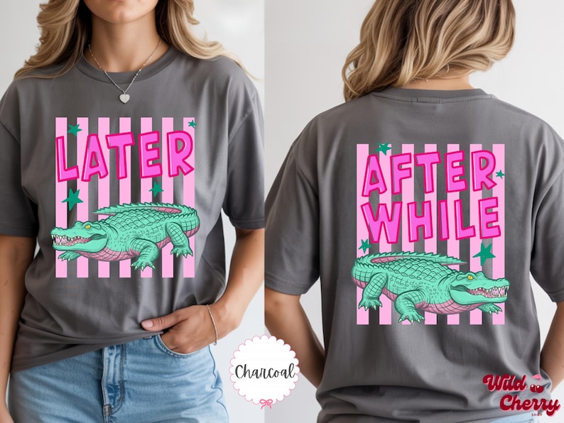 K&ouml;nnte beinhalten: Anthrazitgraues T-Shirt mit einem rosa-wei&szlig; gestreiften Rechteck-Design. Auf der Vorderseite des Shirts steht "LATER" &uuml;ber einer gr&uuml;nen Alligator-Illustration. Auf der R&uuml;ckseite steht "AFTER WHILE" &uuml;ber einer gr&uuml;nen Alligator-Illustration.