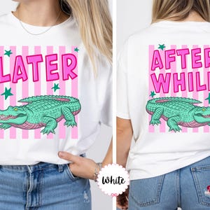 K&ouml;nnte beinhalten: Wei&szlig;es T-Shirt mit rosa und wei&szlig;en Streifen. Auf der Vorderseite steht das Wort "LATER" in Pink, ein gr&uuml;nes Alligator und gr&uuml;ne Sterne. Auf der R&uuml;ckseite stehen die Worte "AFTER WHILE" in Pink, ein gr&uuml;nes Alligator und gr&uuml;ne Sterne.