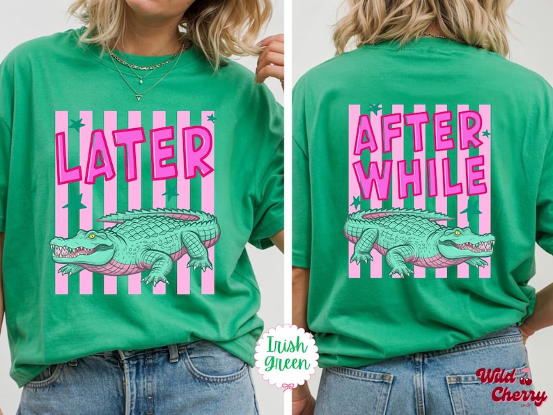 K&ouml;nnte beinhalten: Irisch-gr&uuml;nes T-Shirt mit rosa und wei&szlig;en Streifen. Auf der Vorderseite des Shirts steht das Wort "LATER" &uuml;ber einer Illustration eines tealfarbenen Alligators. Auf der R&uuml;ckseite des Shirts stehen die Worte "AFTER WHILE" &uuml;ber derselben Illustration.
