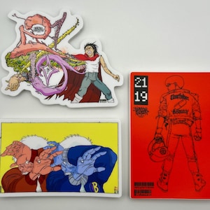 May include: A collection of stickers featuring colorful illustrations. One sticker depicts a figure with a red cape, another shows a person with their hands up, and the third has a red background with a figure and the text "Elnorthader Dispatch".