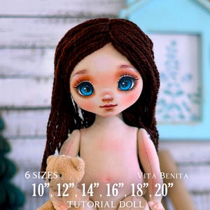 Op de afbeelding: Een handgemaakte tutorialpop met bruin haar en opvallende blauwe ogen. De pop houdt een kleine teddybeer vast. De tekst op de afbeelding luidt "6 MATEN" en geeft maten van 25,4 cm tot 50,8 cm. De tekst "VITA BENITA TUTORIAL DOLL" is ook zichtbaar.
