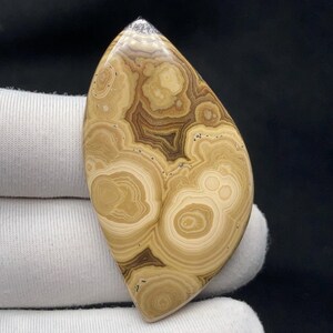 Puede incluir: Un juego de tres tazas de cerámica con un acabado mate moteado. Las tazas son de color crema, gris claro y gris oscuro. Cada taza tiene un diseño simple y minimalista, ideal para café o té.