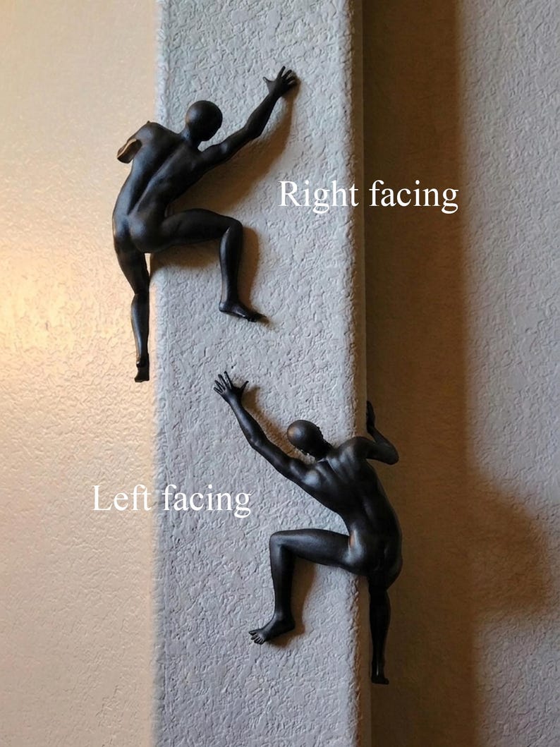 May include: Two matte black wall sculptures depicting human figures in a climbing pose. One figure is positioned as right facing, while the other is positioned as left facing. The figures are shown with arms and legs extended as if scaling a vertical surface.