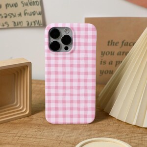 Könnte beinhalten: Handyhülle mit rosa und weißem Vichy-Muster. Die Hülle hat einen Kameraausschnitt. Der Text im Hintergrund lautet "the face you are is a p you".