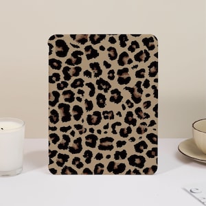 May include: A brown and black leopard print pattern on a square background.