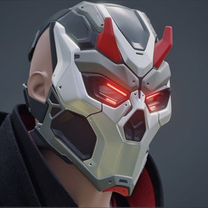May include: A futuristic mask in silver and grey, with red highlights and glowing red eyes. The mask has a skull-like design with angular features, possibly for a costume or cosplay.