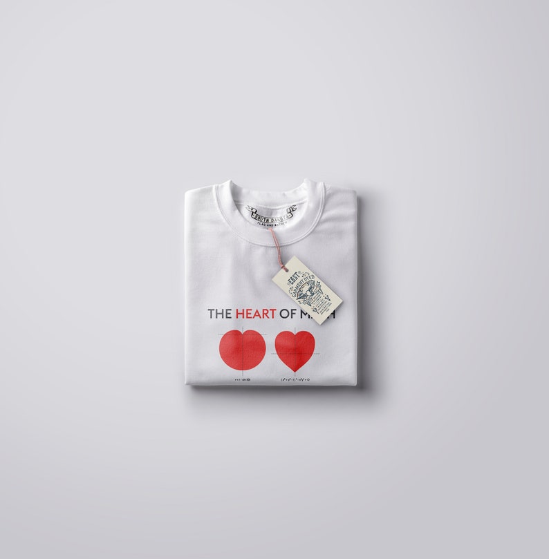 May include: White t-shirt with red hearts and the text "THE HEART OF MY" printed on the front. A brown tag with text is attached to the shirt.