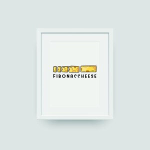 May include: A white framed print with a line of yellow cheese blocks of different sizes, arranged in a Fibonacci sequence. The text "FIBONACCHEESE" is printed below the cheese blocks.
