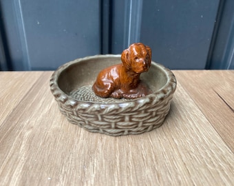 Figura de perro de porcelana Wade en una cesta