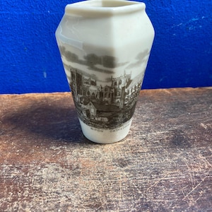 Pode incluir: Um pequeno vaso de cerâmica branco-sujo com uma ilustração a preto e branco da Catedral de Ripon. O vaso tem uma forma geométrica e o texto "Ripon Cathedral".