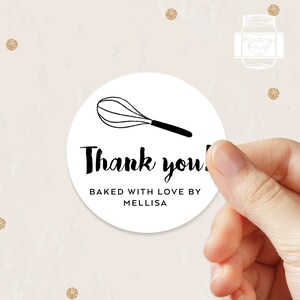 K&ouml;nnte beinhalten: Runder wei&szlig;er Aufkleber mit einer schwarzen Schneebesen-Illustration und dem Text "Vielen Dank! Mit Liebe gebacken von Melissa".