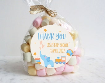 May include: A round thank you tag featuring a blue elephant, a yellow train, and a colourful ball. The tag reads "Thank You" and "Lisa's Baby Shower 8 April 2022".