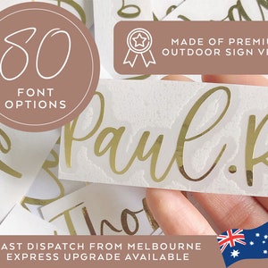 May include: Gold vinyl lettering for a name, "Paul.R", with a white background. The lettering is made of premium outdoor sign vinyl and comes in 80 font options. The image also shows a hand holding the lettering and a small Australian flag.