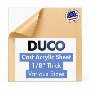 May include: A clear cast acrylic sheet with a protective paper layer partially peeled back. The sheet features the text "DUCO Cast Acrylic Sheet 1/8" Thick Various Sizes" and a "Made in USA" seal.