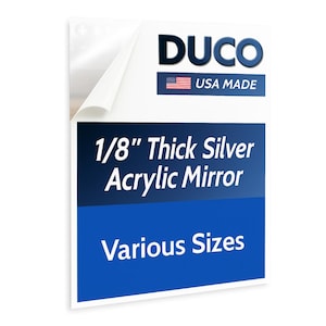 May include: A rectangular silver acrylic mirror, 1/8" thick, with a white border. The text "DUCO USA MADE" is at the top, and below it, "1/8" Thick Silver Acrylic Mirror" and "Various Sizes" are displayed on a blue background.
