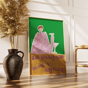 Könnte beinhalten: Gerahmter Kunstdruck mit einer Figur, die einen Cocktail hält, vor grünem Hintergrund. Der Druck enthält den Text "OLIVE BASICALLY MEANS OH, LIFE IS VERY ECLECTIC" in Lila und Gelb. Links ein großer, dunkler Vasen mit getrockneten Pflanzen.