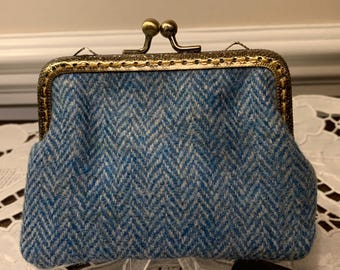 May include: A blue and white patterned fabric coin purse with a gold metal frame and a clasp closure.