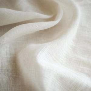 May include: Close-up of a white, textured fabric with a soft, drapey feel.