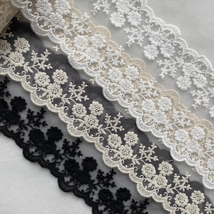 Może przedstawiać: Cztery różne koronki z kwiatowymi wzorami. Koronki są w kolorze czarnym, białym i beżowym. Koronka jest delikatna i misterna.