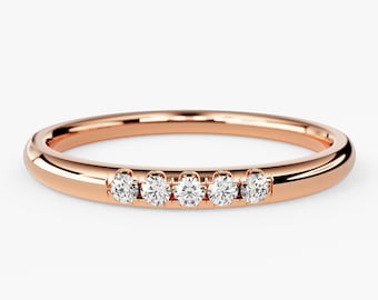 May include: A delicate rose gold band with five small round diamonds set in a row.